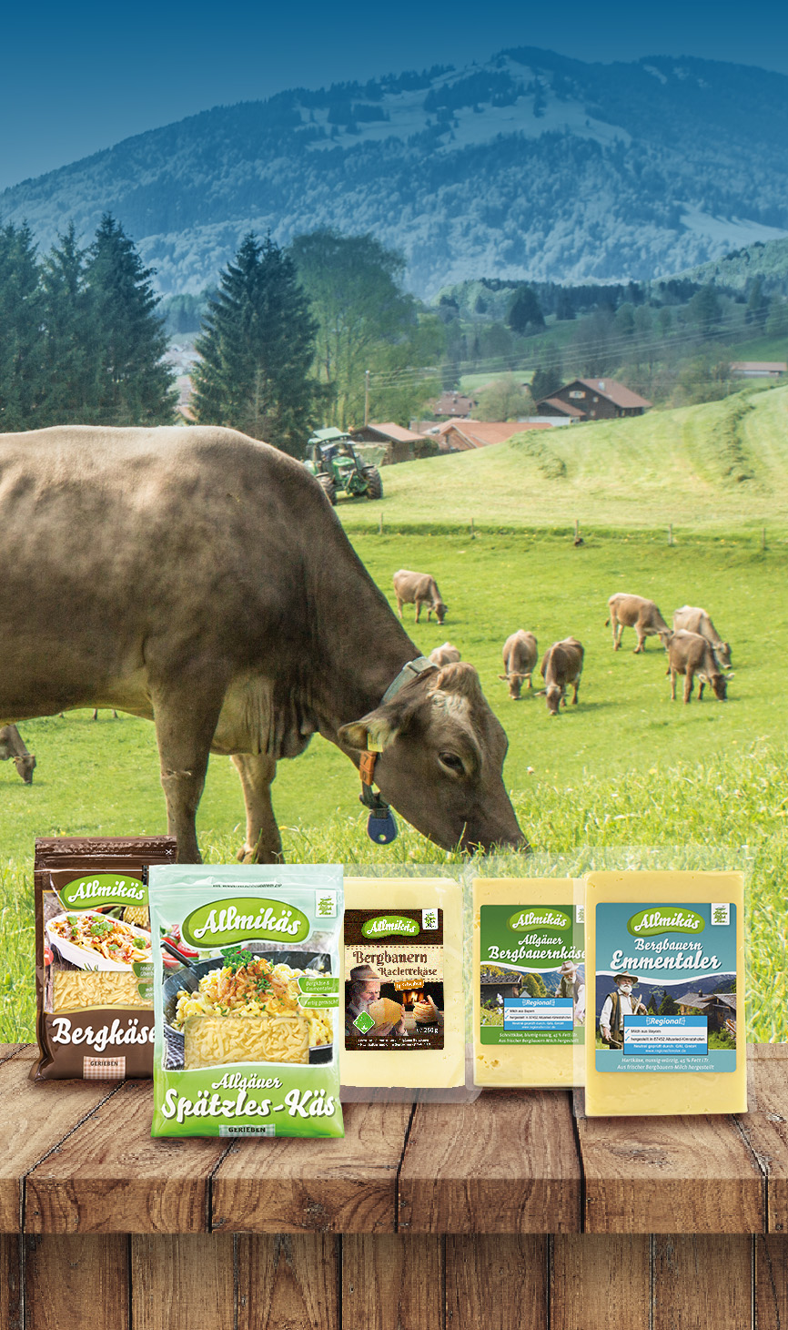 Kuhwiese mit AMK-Käse-Produkten im Vordergrund